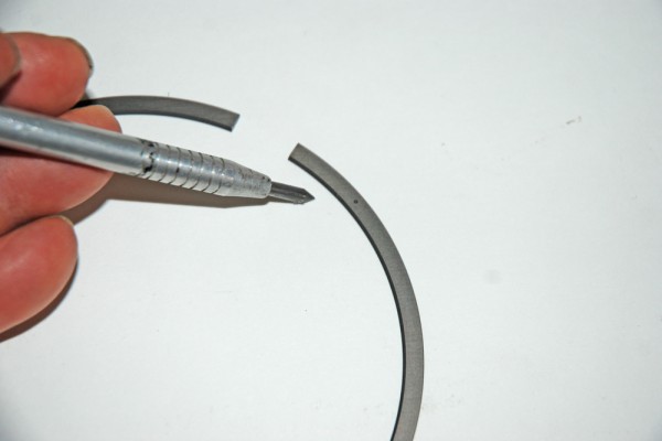 man pointing at gap in a piston ring
