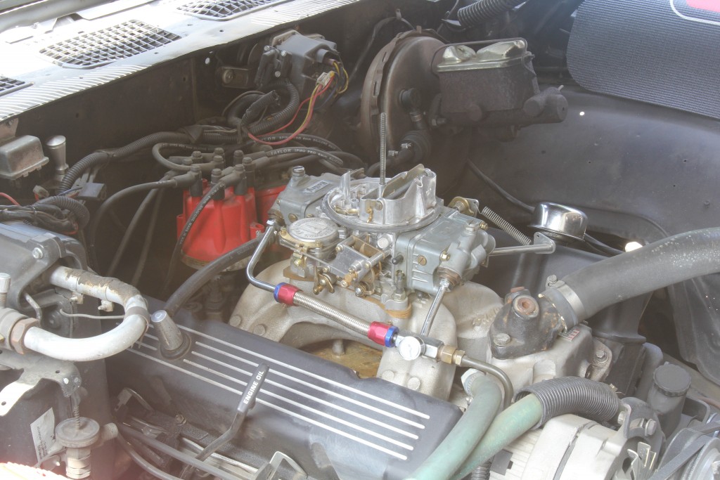 a carburetor atop an old v8 engine