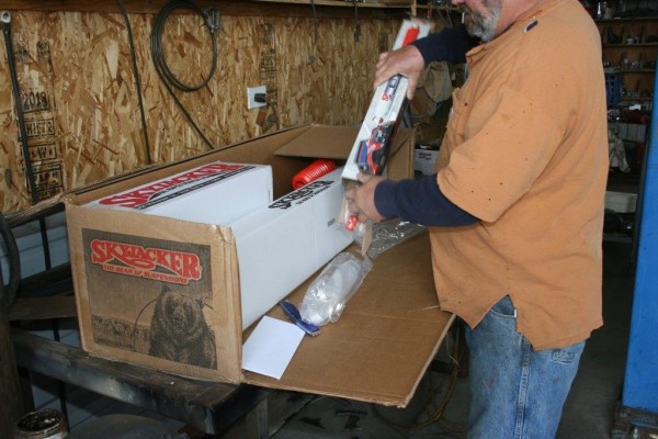 man unboxing skyjacker suspension lift kit from box