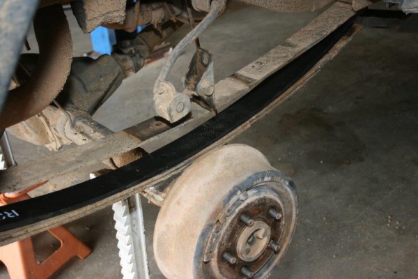 a new leaf spring resting in place on a jeep cherokee xj