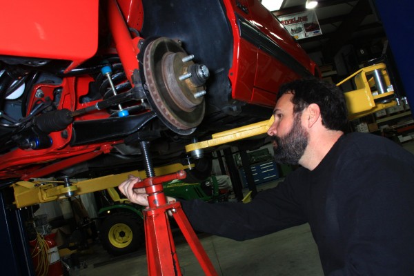 man inspecting ford mustang brake rotor and spindle assembly