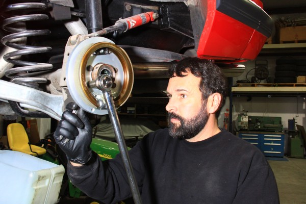 man torqueing bolts on a rear axle housing