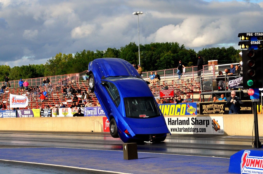 car doing a wheelstand at a dragstrip