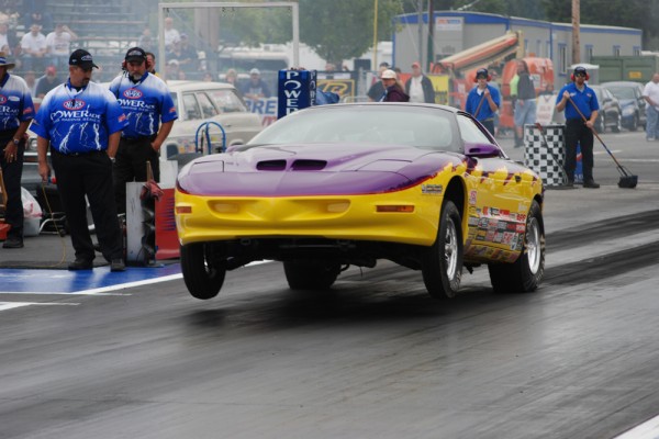 a pontiac firebird drag car launching at dragstrip