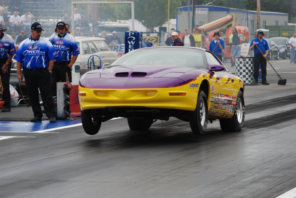a pontiac firebird drag car launching at dragstrip