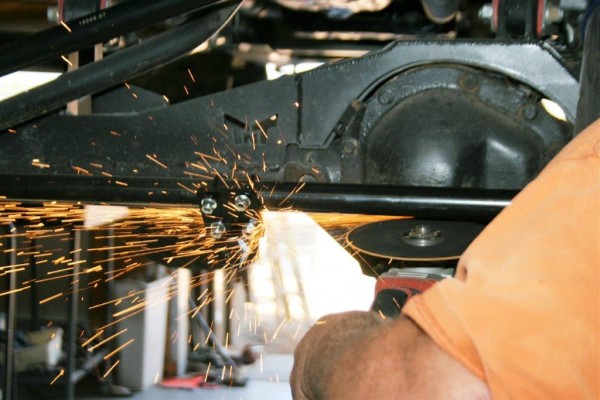man welding parts on a jeep wrangler tj suspension