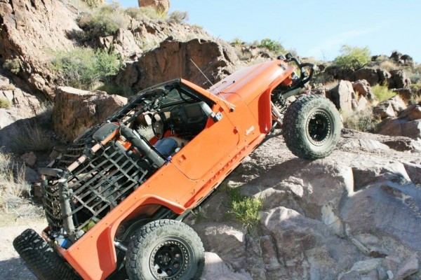 jeep wrangler tj climbing large boulder on desert trail