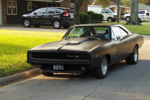 black 1968 dodge charger restomod parked on residential street