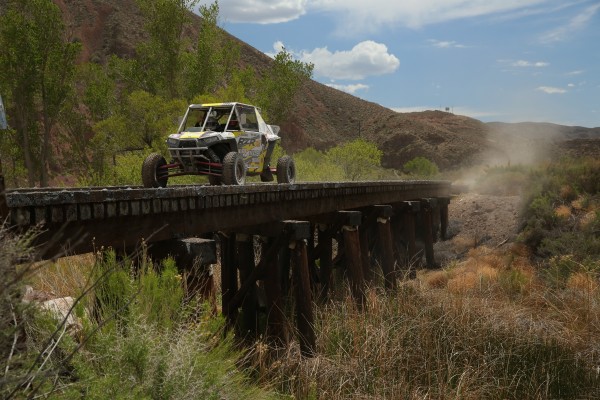 polaris rzr off roader racing across wooden bridge
