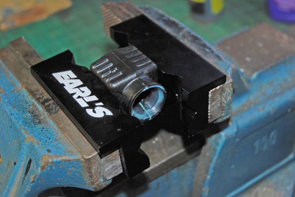 a braided hose fitting in a bench vise