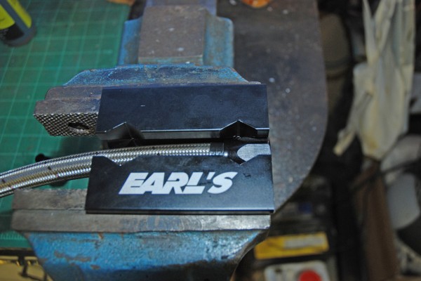 a braided hose fitting in a bench vise