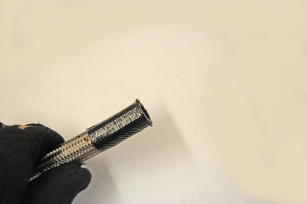 end of a cut braided hose fuel line with tape
