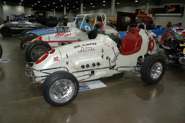 row of midget sprint cars on display
