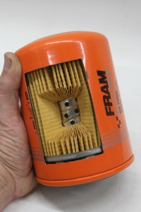This is a cutaway of a Fram racing oil filter. Unfiltered oil enters the outside of the filter, pushes through the pleats in the filter and then exits through the center. Race filters use a less-restrictive filter element that increases oil flow through the filter. The trade-off is race filters do not filter as finely as regular street engine filters.