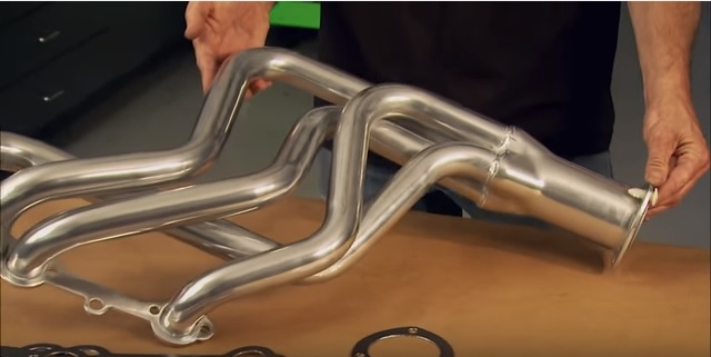 man holding a set of exhaust headers