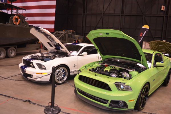 pair of late model ford mustangs at indoor car show