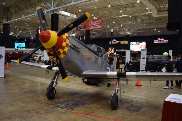 military aircraft on display at indoor car show