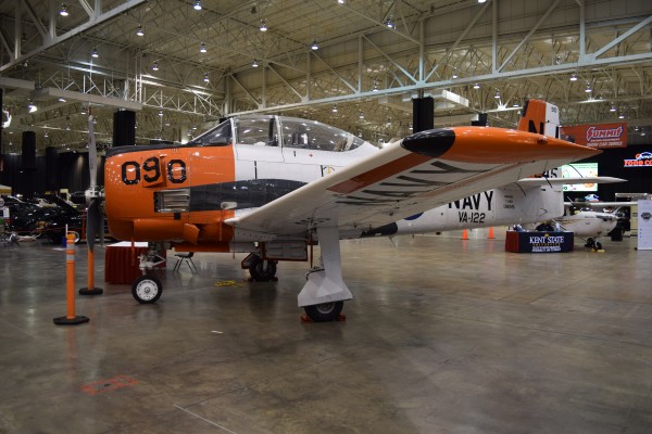 military aircraft on display at indoor car show