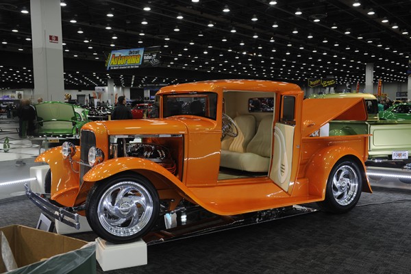 vintage orange hotrod pickup truck at indoor car show