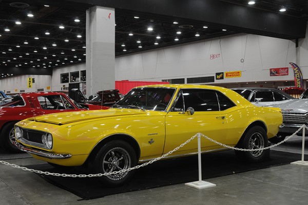 yellow 1967 chevy camaro at indoor car show