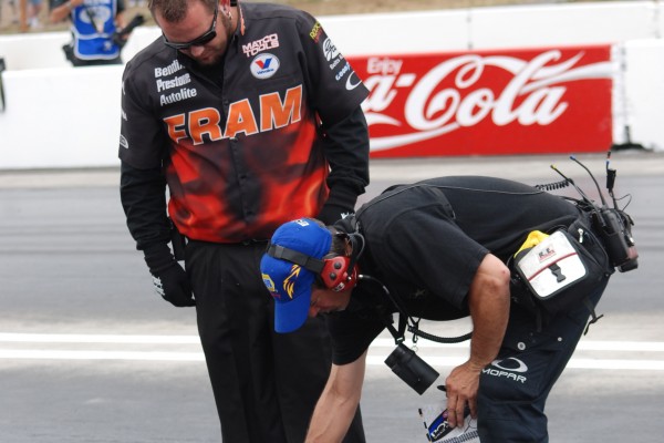 men inspecting drag race track surface