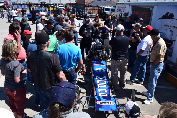 crowd gathering around a front engine nostalgia drag racer