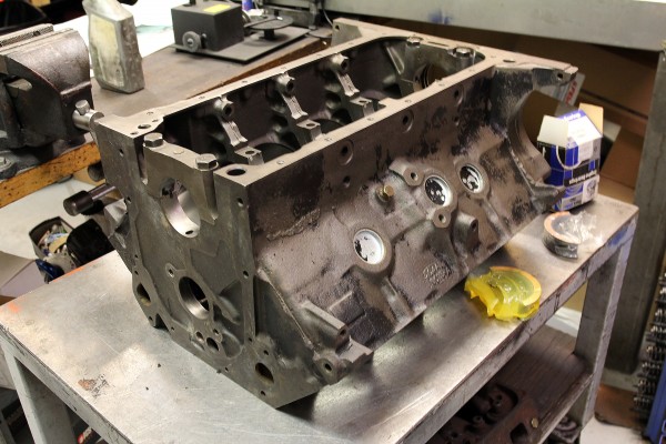 ford 427 engine block sitting on a workbench