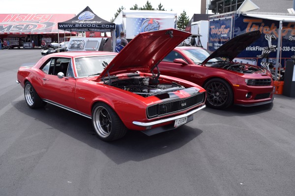 pair of old and new camaros side by side at car show