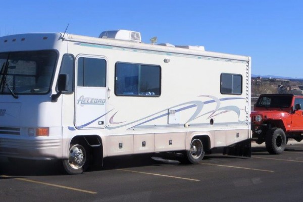 jeep wrangler being towed behind an rv camper