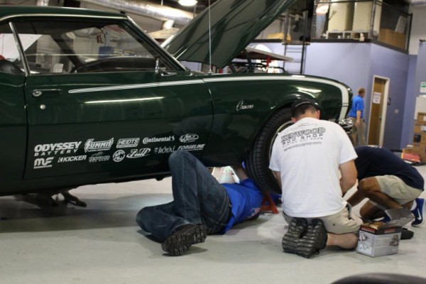 men working on chevy camaro in a work shop