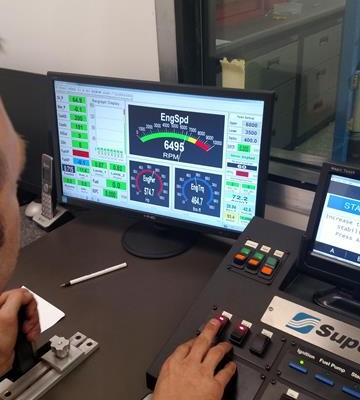 man at engine dyno controls