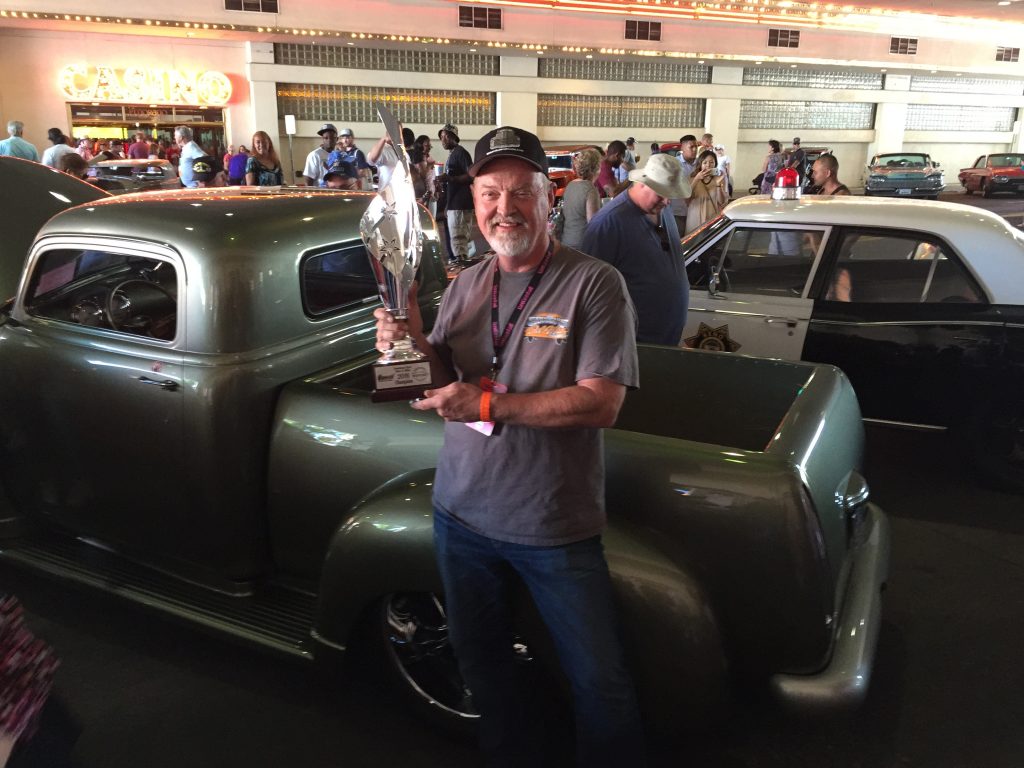 show car builder holding trophy