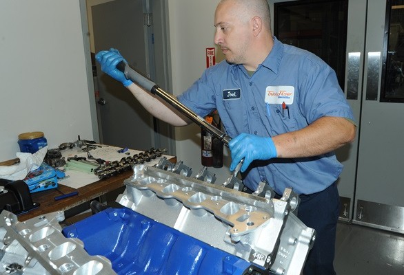 man torqueing down camshaft bearing caps on ford modular ohc engine