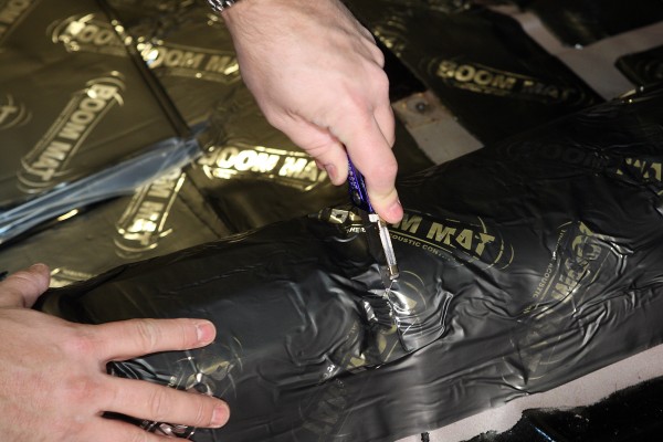 installing boom mat sound deadener on the floor of a classic car