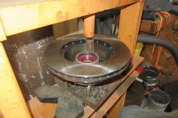 Wheel studs being pressed into a brake rotor