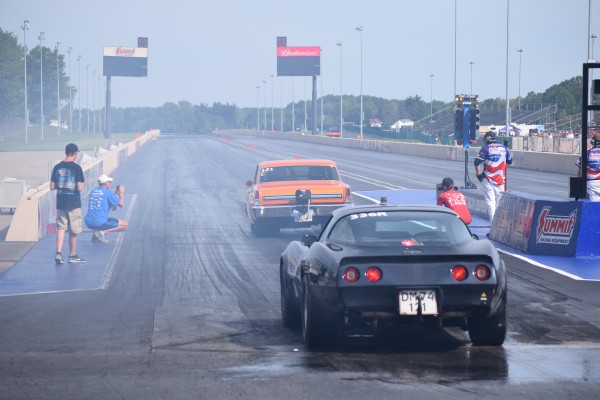 a chevy corvette prepares to stage behind a chevy ii nova at a drag strip
