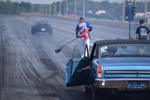 1967 chevy nova 2 preparing to race as crews prep dragstrip track