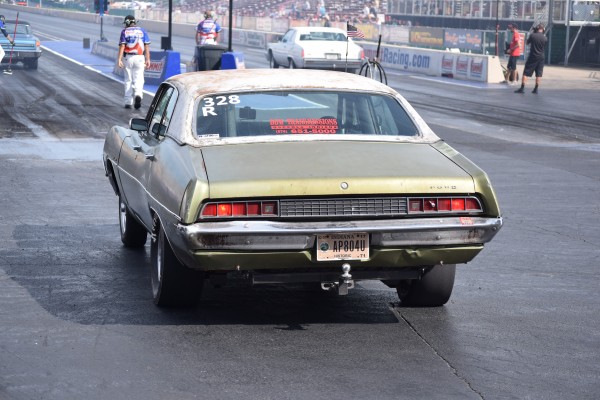 vintage ford sedan preparing to stage at a drag strip