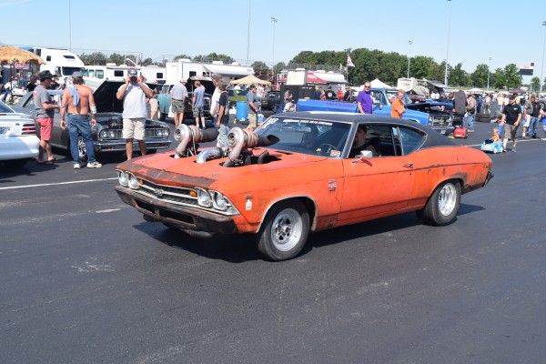 vintage chevy chevelle ss with twin turbocharged engine sticking out of the hood