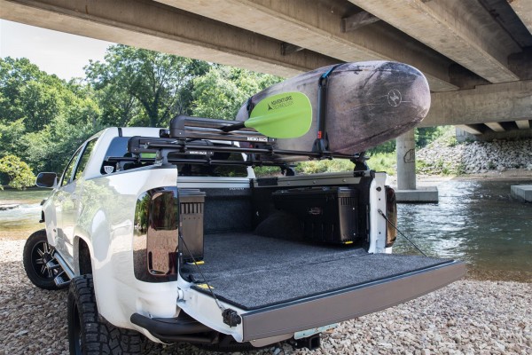 truck with a surf board rack under bridge