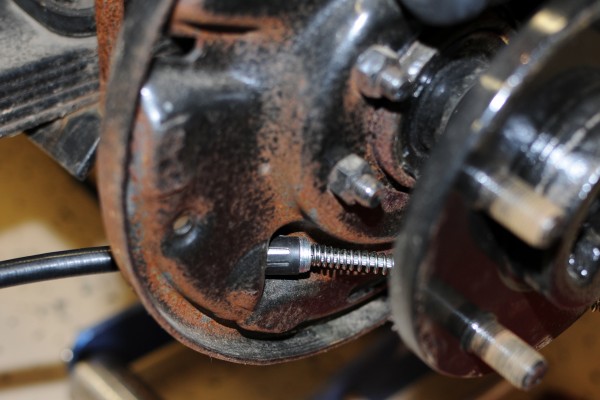 parking brake cable routing through a jeep wrangler brake drum plate