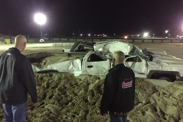 men looking at cars crushed by bigfoot monster truck
