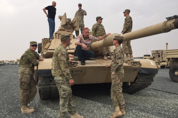 men touring a military tank and base