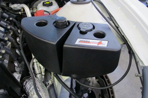 relocated washer fluid and overflow tank