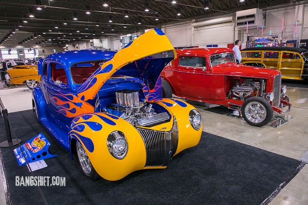 a pair of custom hot rods at an indoor car show