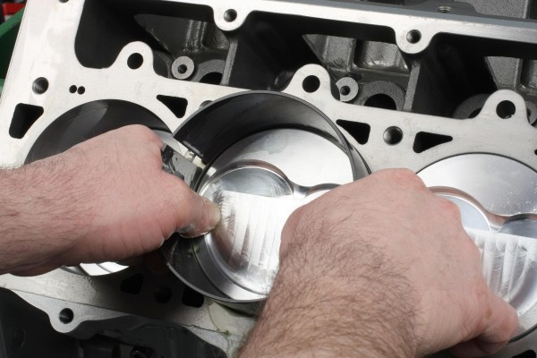 installing pistons with ring compressor into engine block