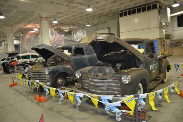 row of classic trucks and panel wagons at a car show