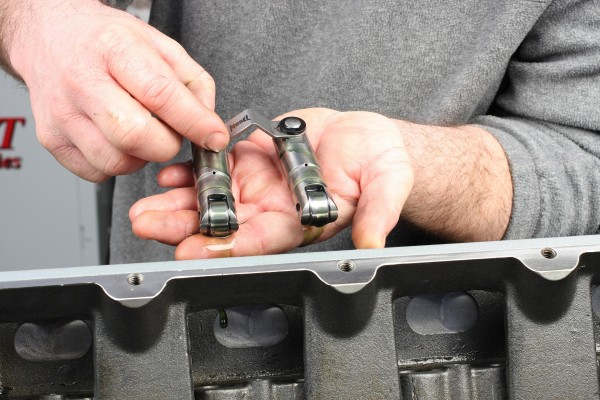 man holding lifters near an engine block