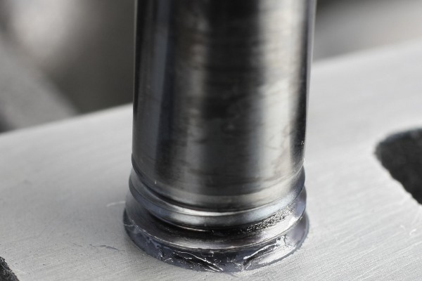 threading a head stud into a cylinder head