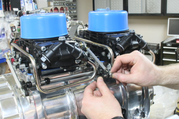 man installing dual carb linkage on supercharged engine